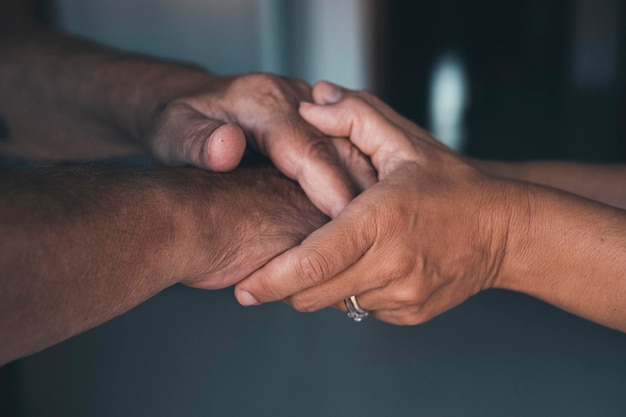 Young woman daughter granddaughter caregiver holding old senior female hand helping elderly mother as concept of older people respect assistance grandparent support two women generations comfort