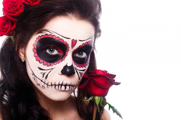 Young woman in day of the dead mask skull face art and rose