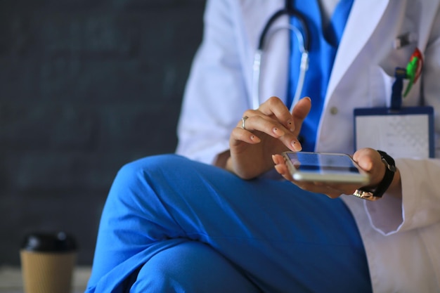 Young woman doctor sitting with your phone