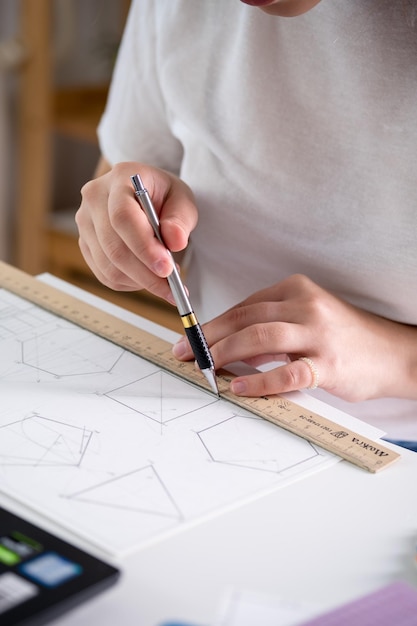 A young woman does her mechanical drawing homework Mechanical drawing education Technical drawings A young woman learns to draw and masters the profession of a mechanical draftsman vertical photo