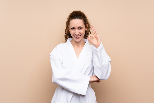 Young woman doing karate showing ok sign with fingers