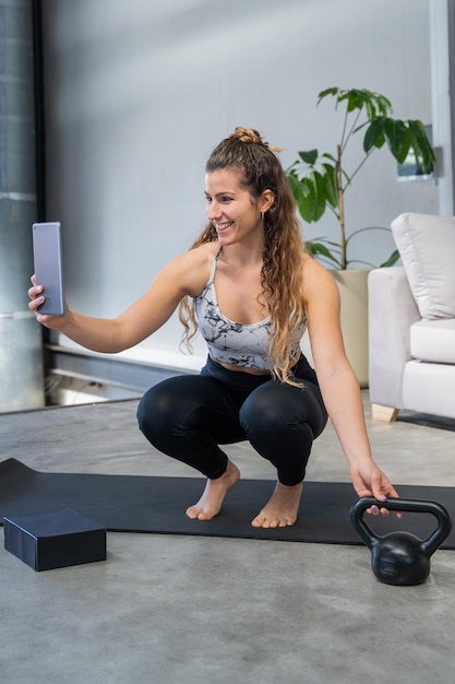 Young woman doing online exercise gym at home