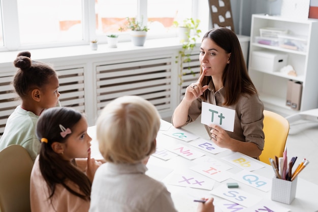 Photo young woman doing speech therapy with children in her clinic