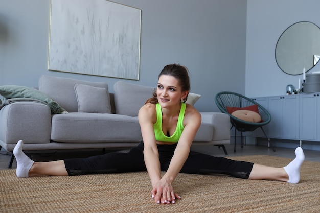 Young woman doing stretching exercises at home