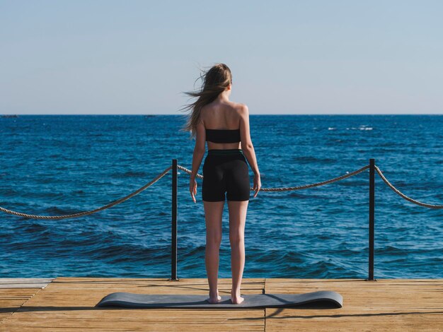 Young woman doing yoga on the beach