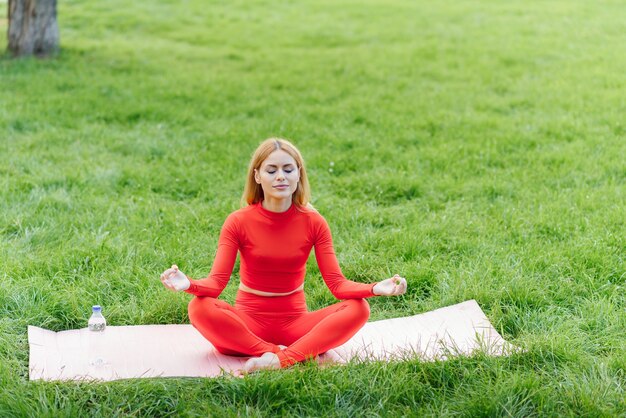 Young woman doing yoga exercise in green park