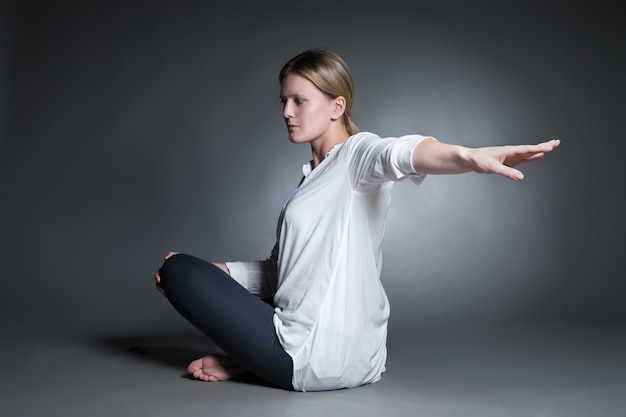 Photo young woman doing yoga isolated against dark background