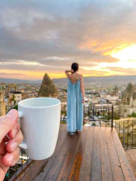 Young woman in dress on the roof with amazing view of Cappadocia in Turkey