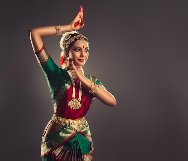 Young woman dressed in traditional Indian dance suit is shows beauty of classic dance bharatanatyam