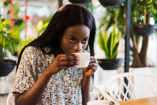 Young woman drinking coffee in modern cafe