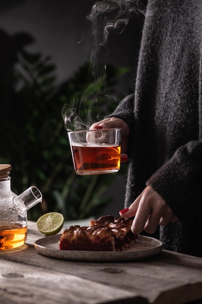 Young woman drinking hot tea with cranberry pie