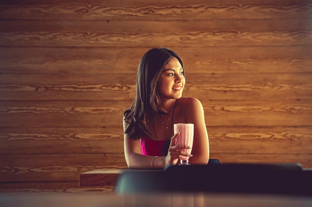 Young woman drinking a soft drink in shopping center