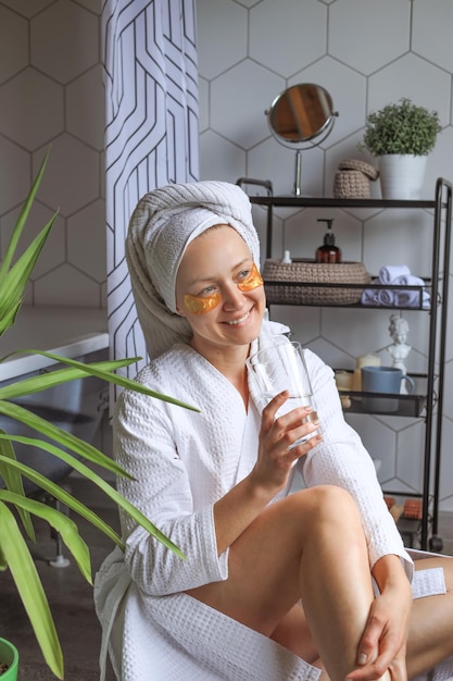 Young woman drinking water after taking a shower replenishing water balance healthy daily habits detox