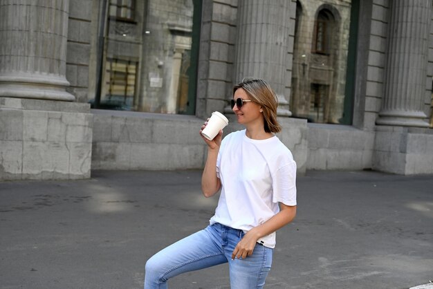 Photo young woman drinking water in city