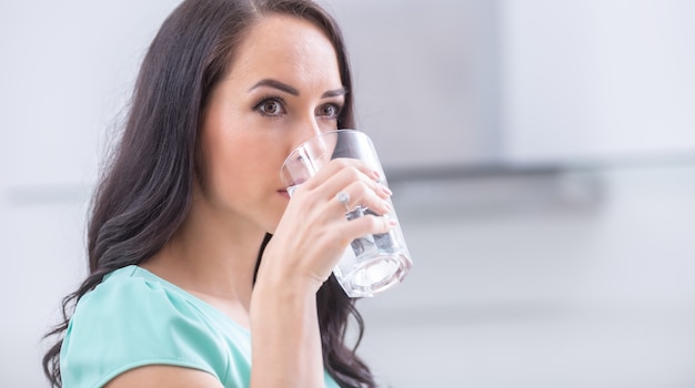 Young woman drinks clean water adheres to drinking regime.