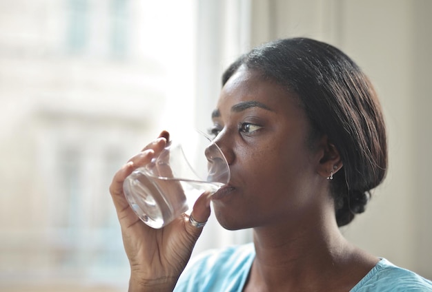 young woman drinks a glass of water