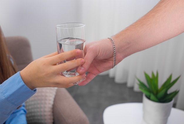 young woman drinks water from a glass