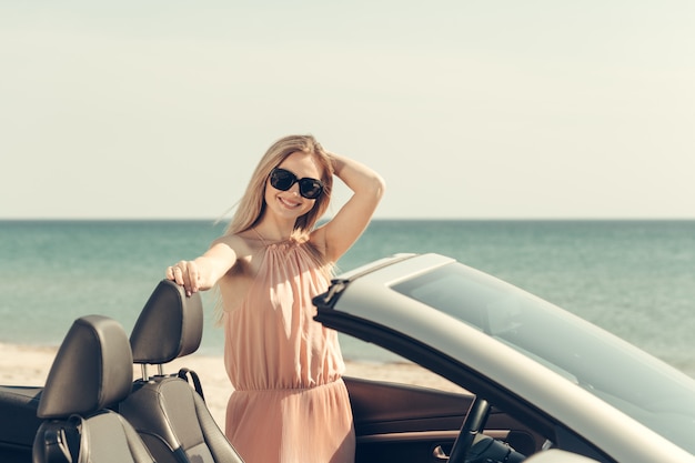 Young woman drive a car on the beach