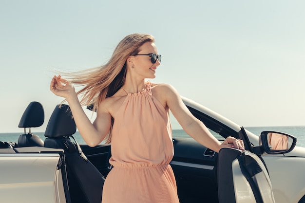 Young woman drive a car on the beach