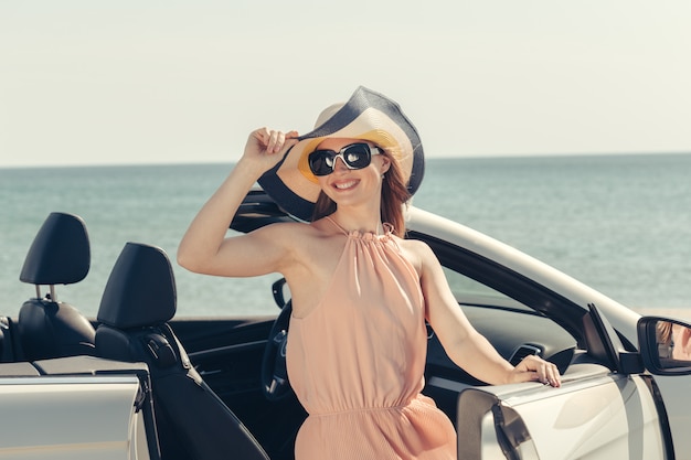 Young woman drive a car on the beach