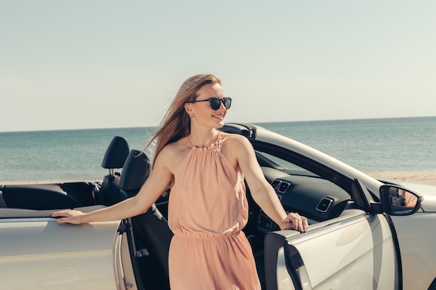 Young woman drive a car on the beach