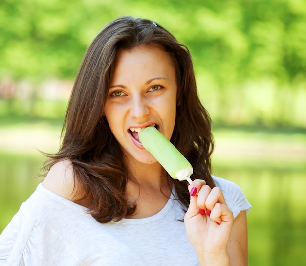 Young woman eating ice-cream sunny day outdoors