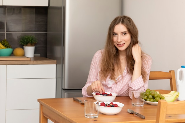 Young woman eating oatmeal with fruit