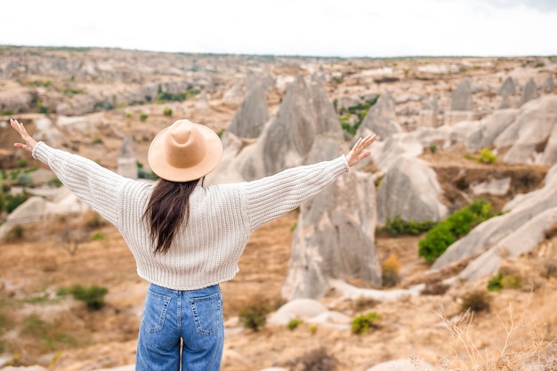 Young woman on the edge of canyon in cappodocia