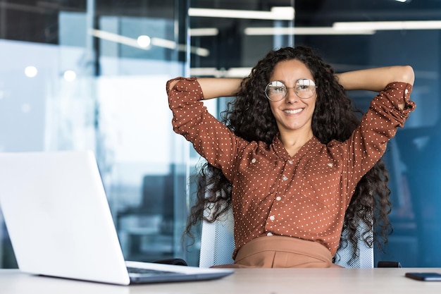 Young woman engineer developer programmer works in the office inside the it company satisfied with