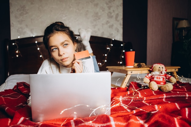 Young woman enjoying shopping online for Christmas.