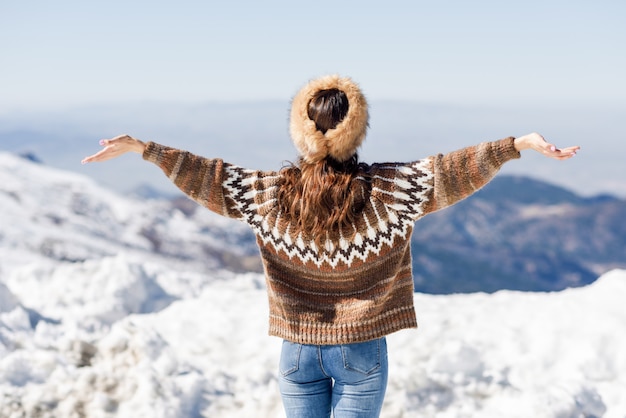 Young woman enjoying the snowy mountains in winter