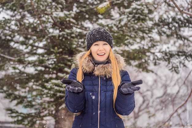 Young woman enjoys a winter snowy day in a snowy forest