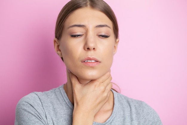 Young woman feeling exhausted and suffering from neck pain health concept