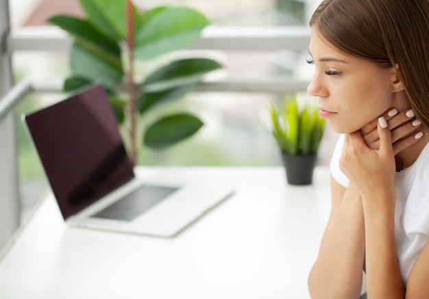 Young woman feeling exhausted and suffering from neck pain health concept