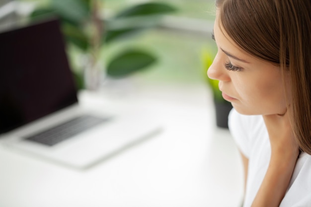 Young woman feeling exhausted and suffering from neck pain health concept