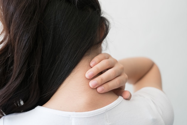 Young woman feeling exhausted and suffering from neck pain, Health concept.