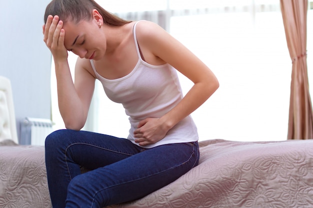 Young woman feels abdominal pain during the period menstruation