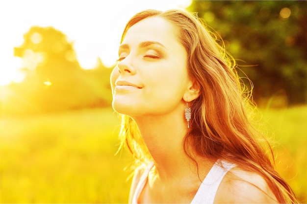 Young woman on field under sunset light