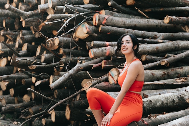 Young woman in fitness clothes smiling to camera while sitting in a bunch of trunks