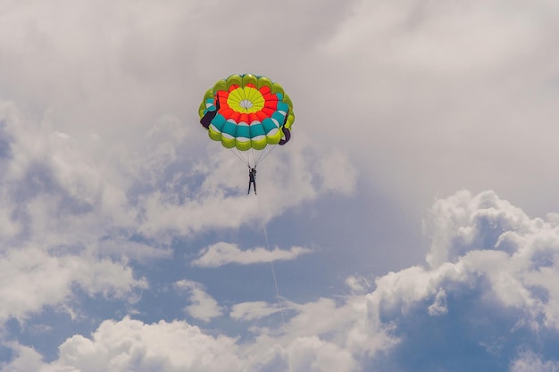 Young woman flies on a parachute among the clouds.