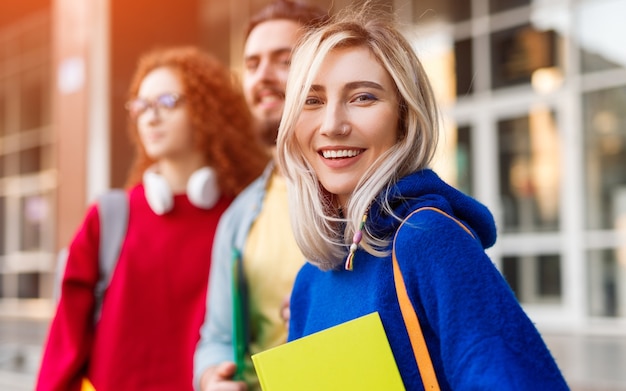 Young woman and friends with notebook smiling