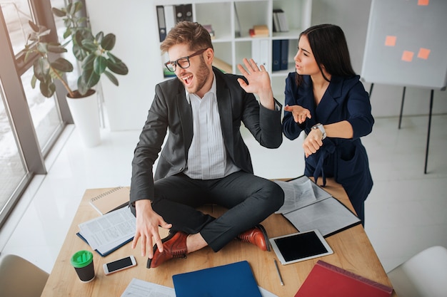 Young woman get nervous by pointing on watches and looking at man