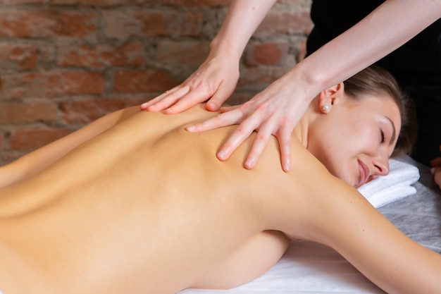 Young woman getting a back massage in a spa salon Beauty treatment concept