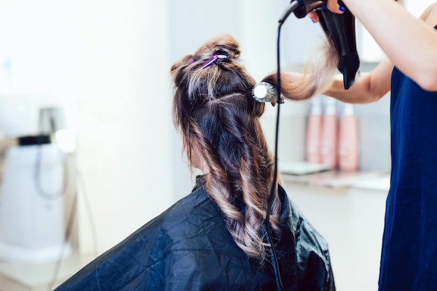 Young woman getting beautiful hairstyle in hair salon.