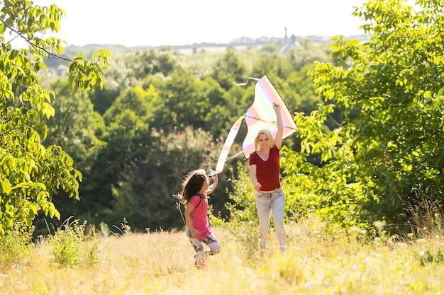 Young woman and girl flying a kite