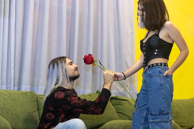 Young woman giving a red rose to her boyfriend