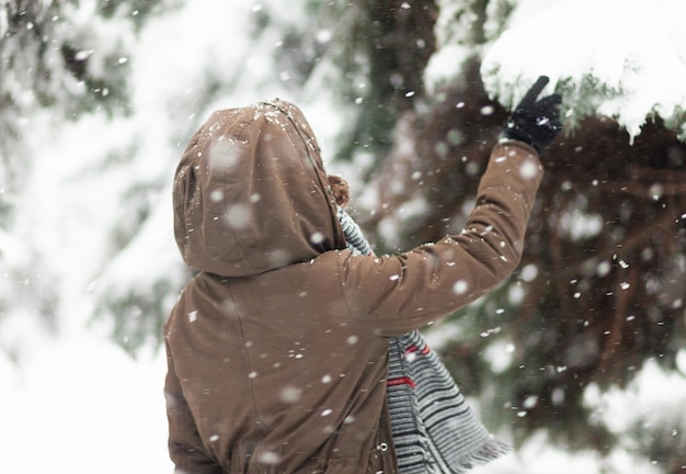 Young woman glad to snow Back view