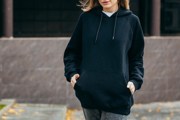 Young woman in glasses and black hoodie