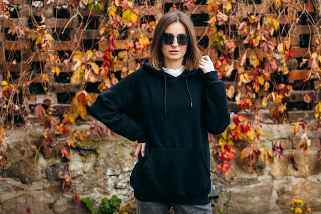 Young woman in glasses and black hoodie