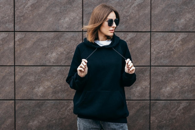 Young woman in glasses and black hoodie